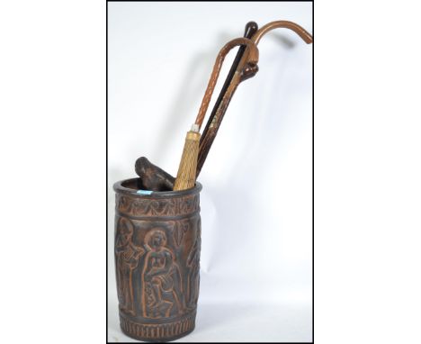 A vintage Continental terracotta stick stand decorated with figures containing various sticks, parasol etc