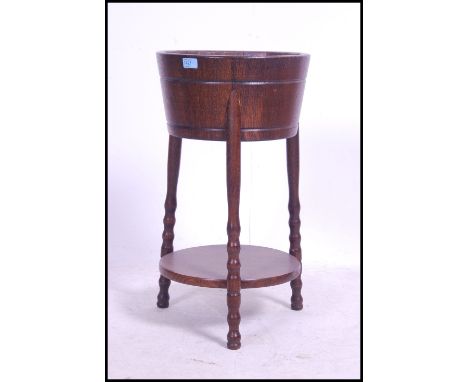 A carved oak Regency revival ice bucket - wine cooler of barrel form being raised on shaped supports - ideal as a planter / t