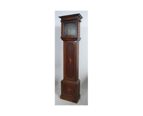 An 18th century John Coates of Cirencester brass faced longcase clock movement set within a later 19th century oak geometric 