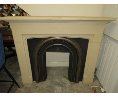 A MODERN CAST IRON FIRE SURROUND WITH A COMPOSITE SURROUND