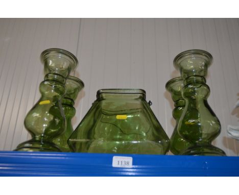 A green glass candle lantern and four similar vases