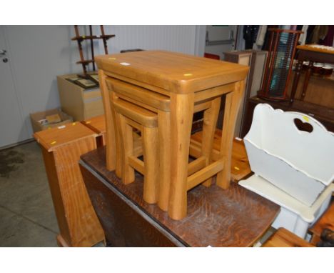 A good quality light oak nest of three occasional tables