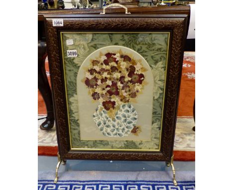 Carved wood framed firescreen with brass handle and feet decorated with dried flowers