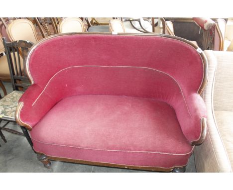 A red upholstered curved backed two seater sofa 