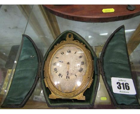 BEDROOM CLOCK, a finely engraved oval face easel bedroom clock with carrying case and key 