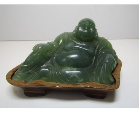 JADE, a green jade carving of reclining pot bellied deity on hardwood stand, 4" width  