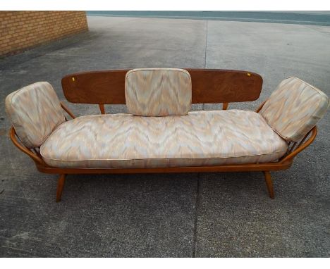 An Ercol light elm and beech three-seater sofa / day bed designed by Lucian R Ercolani classic model number 355, with origina