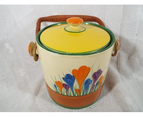 A Clarice Cliff lidded biscuit barrel decorated in the Crocus pattern with swing handle, 16cm (h) x 14cm (dia) Est £100 - £14