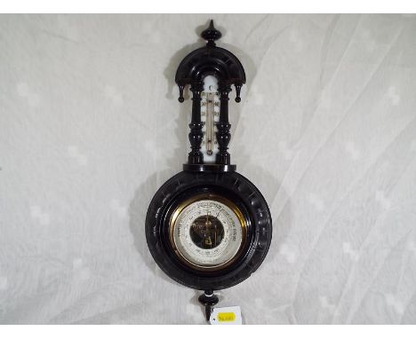 A good carved wood case wall-mounted aneroid barometer and thermometer, the dial having open centre to display the mechanism.