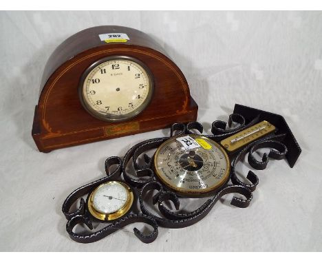 A A polished and inlaid wood cased wind-up mantel clock together with a decorative wall-mounted scrolling ironwork thermomete