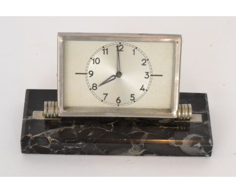 A 1930s French Art Deco mantle clock the hinged chromium case enclosing a silvered dial and Arabic numerals, on a rectangular
