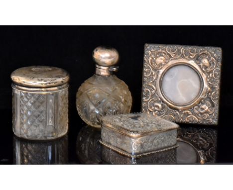 A Victorian hallmarked silver trinket box of square form with embossed C scroll and foliate decoration, crimped rim, hinged l