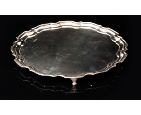 A mid 20th Century hallmarked silver circular salver with pie crust border and raised on three bracket feet, diameter 36cm, w