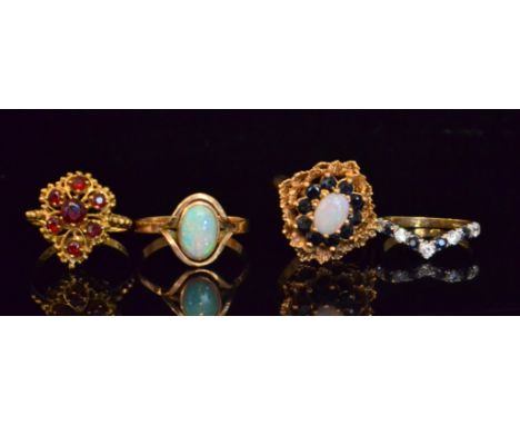 Four 9ct stone set rings to include a garnet, sapphire and opal and a single stone opal example. (4)