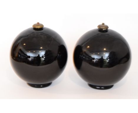 A pair of 1930s Belgian Art Deco glass lamp bases of footed spherical form in black glass with brass collar mounts, acid mark
