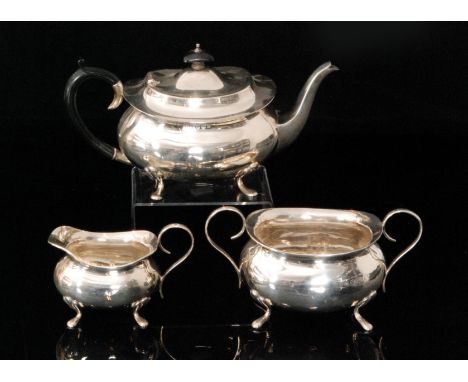 A George V hallmarked silver three piece tea service comprising of teapot, cream jug and two handled sugar bowl, each of plai