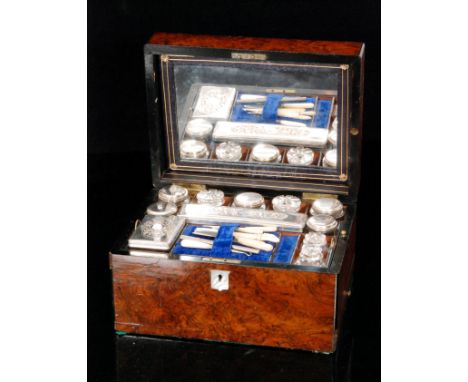 A Victorian burr walnut dressing case the mirrored interior above a trap compartment inset with plated topped jars, boxes and