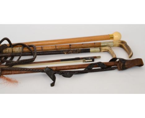 Three 19th Century horn handled leather riding crops together with an ivory ball shaped handle walking stick and a violin bow