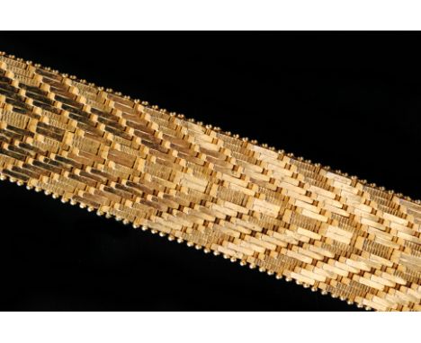 A modern 18ct yellow gold flexible strap bracelet, the links of ridged fish scale design with tongue and box clasp, weight 59