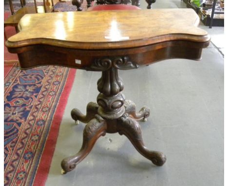 A VICTORIAN WALNUT SERPENTINE CARD TABLE ON LOBED PILLAR AND QUADRUPLE CARVED LEGS 