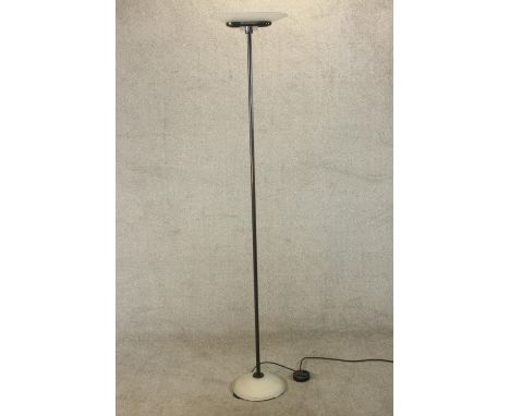 An Arteluce Jill A 380 floor standing uplighter lamp, with a clear glass shade on a tubular stem with a circular white painte