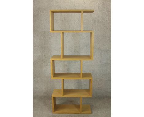 A contemporary light oak room divider, with an arrangement of open shelves. H.180 W.70 D.30cm. 