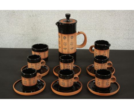 Gordon Fox for Kentmere pottery; a stoneware coffee set to seat six, with dark brown glaze and incised sunflower decoration. 