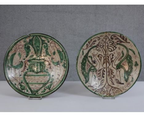 A pair of late 18th century Spanish Teruel majolica hand painted pottery urn and peacock design plates. Diam.26cm 