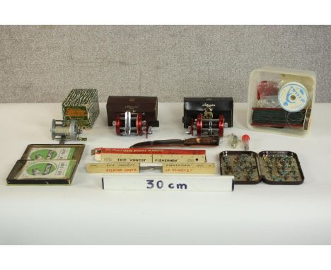 A collection of vintage fishing equipment, including two leather cased Ambassadeur fishing reels, a tin of fishing flies, lin