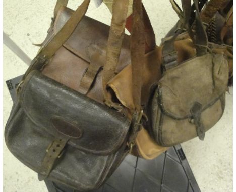 A canvas and lether cartridge bag stamped 'Bussey & Co, London', two leather and pigskin cartridge bags and a canvas and leat