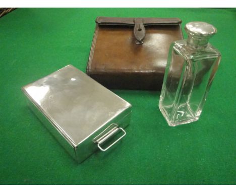 A leather saddle lunch box containing a Swaine & Adeney sandwich box, together with a silver mounted cut glass flask