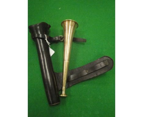A brass hunting horn housed in a leather case