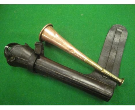 A copper and brass hunting horn stamped "Made in England", housed in a leather case