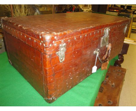 An early 20th Century Louis Vuitton style crocodile skin covered suitcase with three locks, the central one marked "Patent Lo