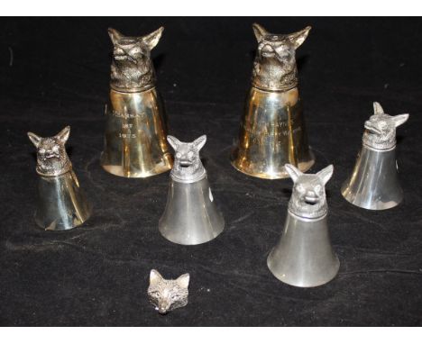 Two large stirrup cups the handles formed as fox heads together with a set of four stirrup cups one with handle and a snuff b