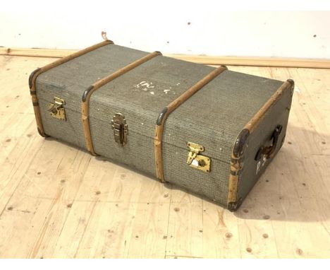 A travelling trunk, first half of the 20th century, wooden bound and with leather carry handle to each end, H32cm, W93cm, D54