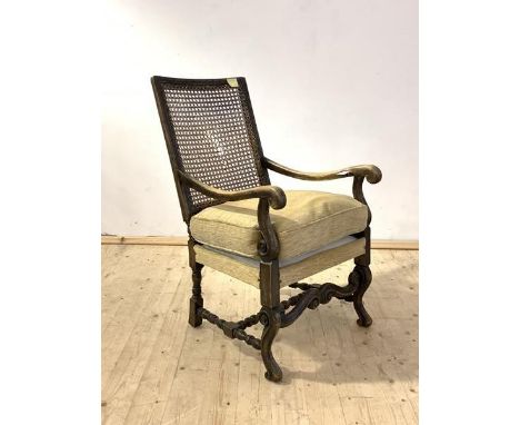 A 17th century style stained walnut(?) open arm chair, with cane back panel(A/F), scrolled arm rests, raised on scrolled fron