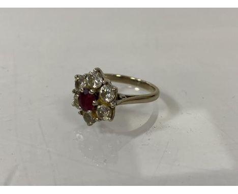 An 18ct gold cluster ring, London, with six diamonds surrounding ruby, size L