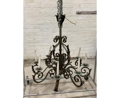 An early 20th century French patinated wrought iron chandelier, the hammered copper boss in the form of four oak leaves over 