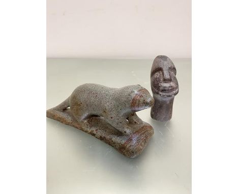 An Inuit carving of an otter of variegated green and brown soapstone, engraved verso WPO, and an African soapstone carving of