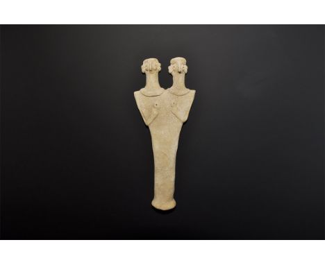 1180-700 BC. A flat-backed ceramic figurine depicting a female with two heads; the eyes and breasts domed with round recesses