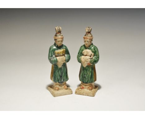 A matched pair of hollow undated archaistic ceramic figurines, each an attendant on a square base in green robe with sash and