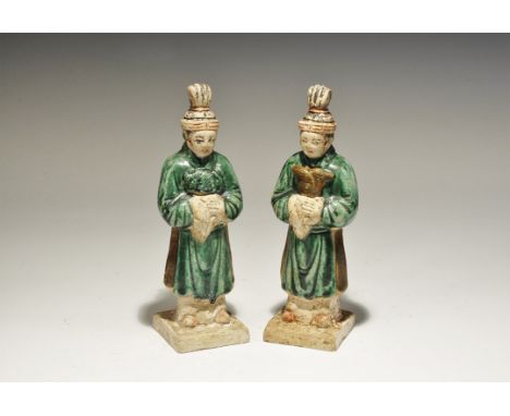 A matched pair of hollow undated archaistic ceramic figurines, each an attendant on a square base in green robe with sash and
