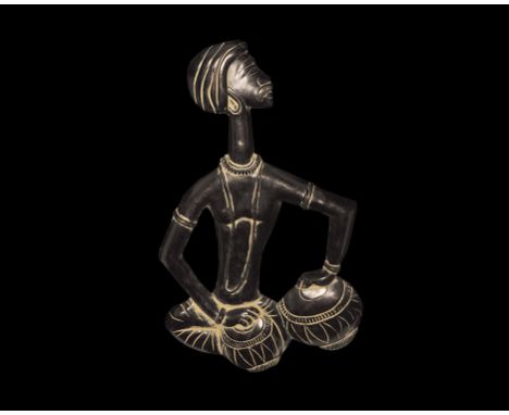20th century AD. A high-relief plaque depicting a seated male with bare torso, turban, bracelets and necklaces, playing two d