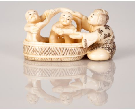 Old Bone Netsuke with a scene of a Mother Bathing Her Children in a Water Tub.  Item illustrated by hand and signed.  Dimensi