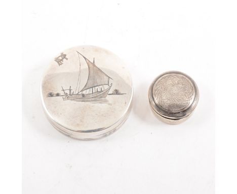 A white metal patch box with mirror depicting a niello sailing junk, 50mm, and another 25mm pill box with engine turned cover