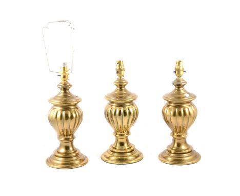 Three lacquered brass lamp bases, fluted baluster form, 37cm; and an opaque shade.