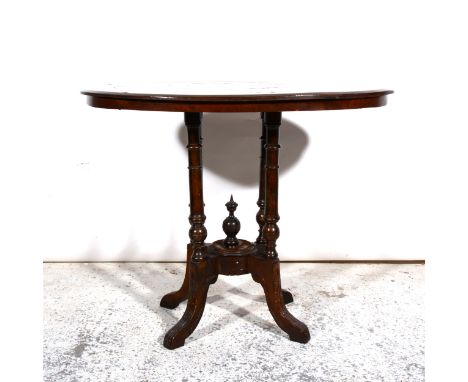 An oval occasional table on four turned supports with centre finial.86cm x 52cm