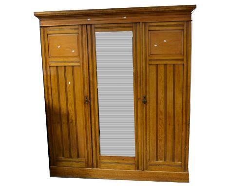 Victorian stained walnut triple wardrobe, moulded cornice above a central mirrored door enclosing a bank of four open shelves