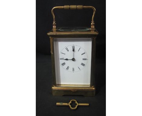 LATE 19TH/EARLY 20TH CENTURY GILT BRASS TWO TRAIN CARRIAGE CLOCK with swing handle to the gorge case above oval beveled glass